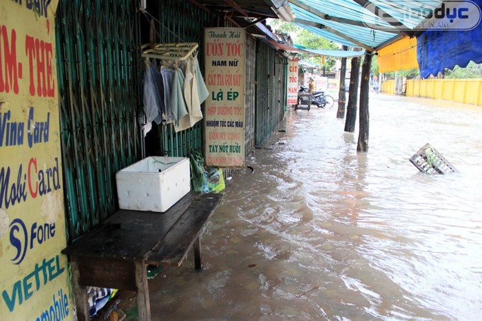 Nhiều cửa hàng buôn bán nhỏ ở Hà Nội đã phải đóng cửa giữa biển nước. Ảnh chụp tại phố Trần Bình (Cầu Giấy, Hà Nội). Trên thực tế, tại hầu khắp các khu chợ khác tại Hà Nội cũng cùng chung tình cảnh vắng vẻ, đìu hiu như vậy.